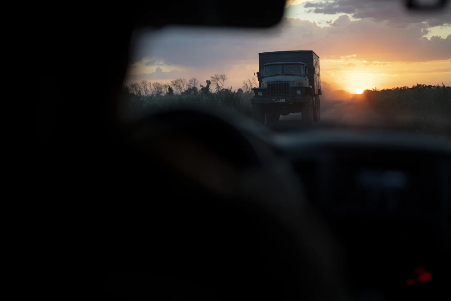 Українська армійська вантажівка проїжджає повз українських бійців підрозділу безпілотників у сутінках на околицях Кремміна, Україна, неділя, 20 серпня 2023 року. Завдання підрозділу безпілотників – знищити важку техніку, бронетехніку та піхоту Росії